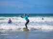 Go ride a wave surfing instructor and student riding a wave