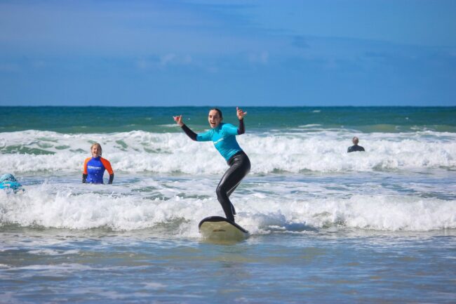 Go ride a wave surfing instructor and student riding a wave